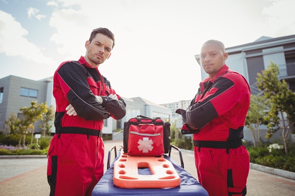 portrait of smiling paramedics standing with arms crossed