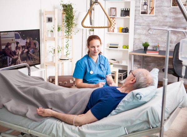 female doctor with stethoscope sharing comfort to old man