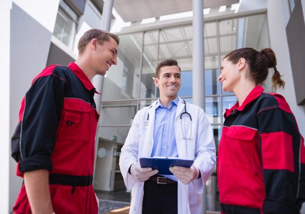 doctor talking to paramedic in corridor at hospital